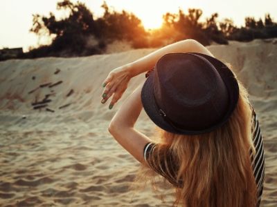 A woman who is afraid of getting spider veins shields her face from the sun.