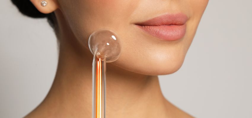 The woman happily tries a high-frequency facial.