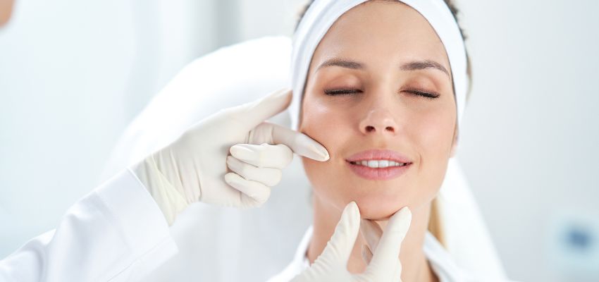 Medical professional assessing botox injection sites on a relaxed female patient.