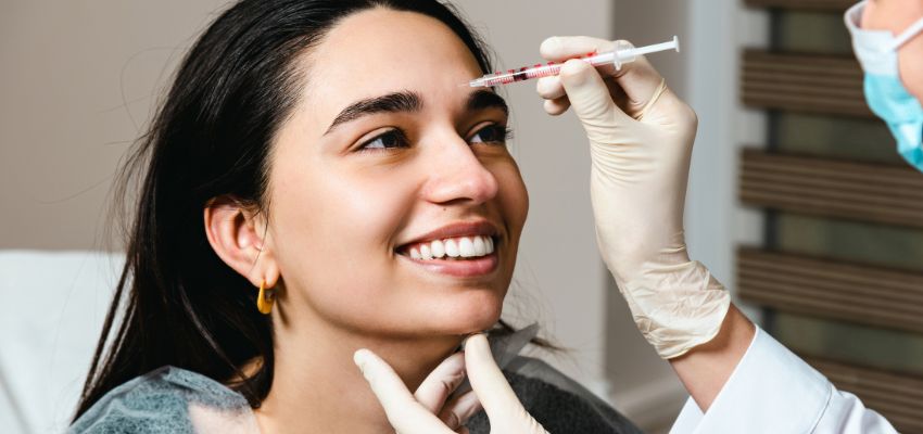 Skincare specialist examining botox injection sites on a woman's face.
