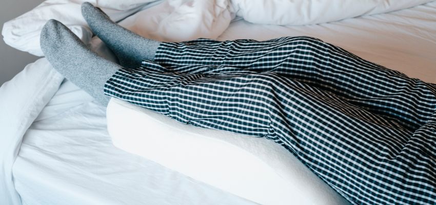 The woman raises her legs when sleeping.