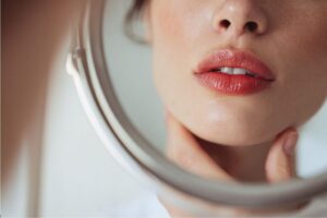 The woman wants to enhance the appearance of her lips.
